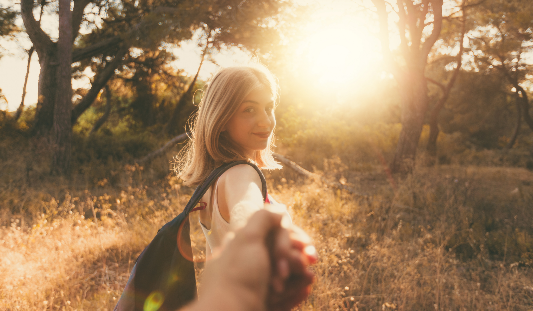 woman leading her boyfriend by the hand