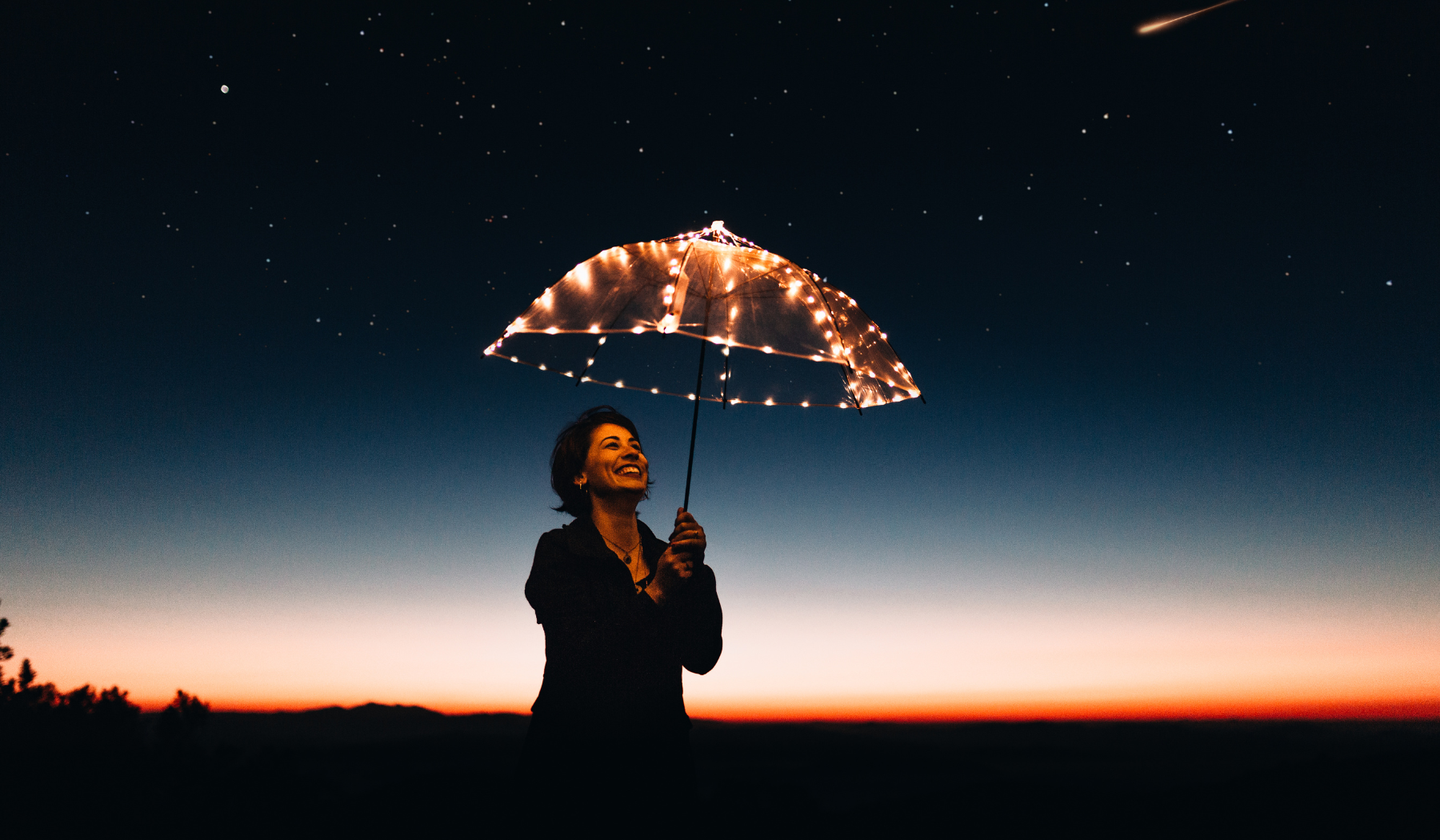 happy woman at dusk with an umbrella